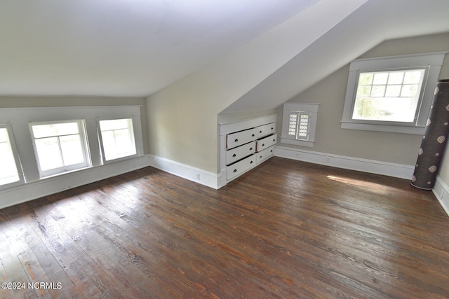 bonus room with dark hardwood / wood-style flooring and vaulted ceiling