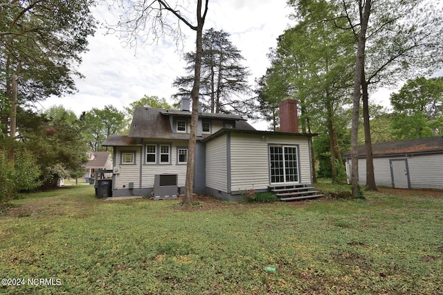 rear view of property featuring a lawn