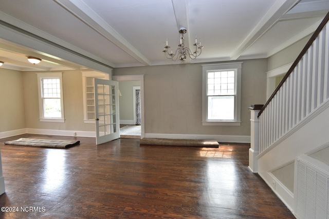 unfurnished living room with dark wood-type flooring, crown molding, and a notable chandelier