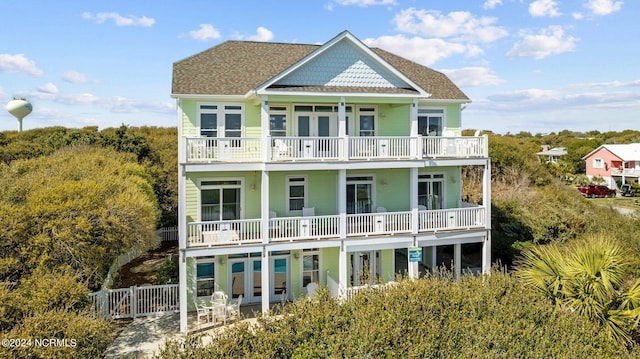 rear view of property featuring a balcony and a patio area