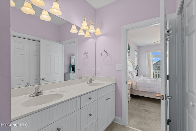 bathroom featuring tile flooring, oversized vanity, an inviting chandelier, and dual sinks