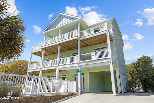 rear view of house with a balcony and a carport