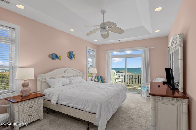 carpeted bedroom with multiple windows, a water view, access to outside, and ceiling fan