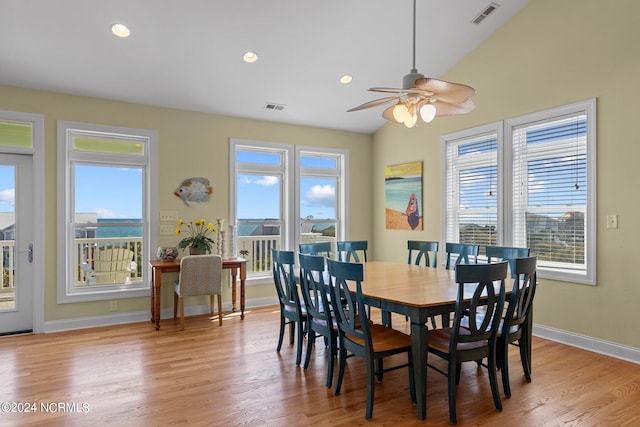 dining space featuring lofted ceiling, light hardwood / wood-style flooring, and a healthy amount of sunlight