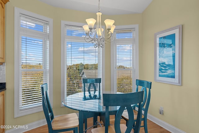 dining area with a notable chandelier, light hardwood / wood-style flooring, and plenty of natural light