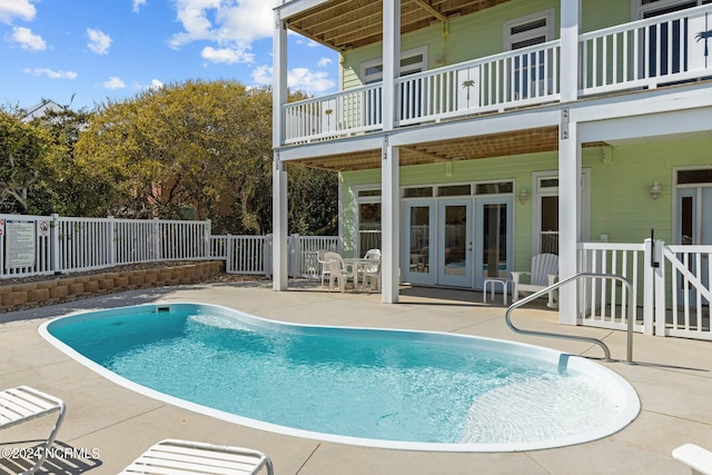 view of swimming pool featuring french doors and a patio area