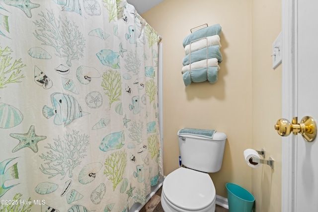 bathroom featuring a shower with shower curtain and toilet