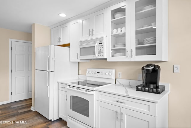 kitchen featuring white appliances, dark hardwood / wood-style floors, white cabinetry, and light stone counters