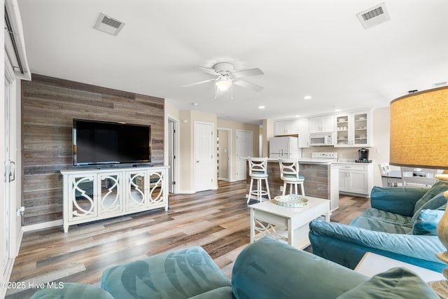 living room featuring light hardwood / wood-style floors and ceiling fan