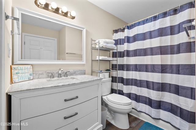 bathroom featuring hardwood / wood-style flooring, vanity, toilet, and a shower with curtain