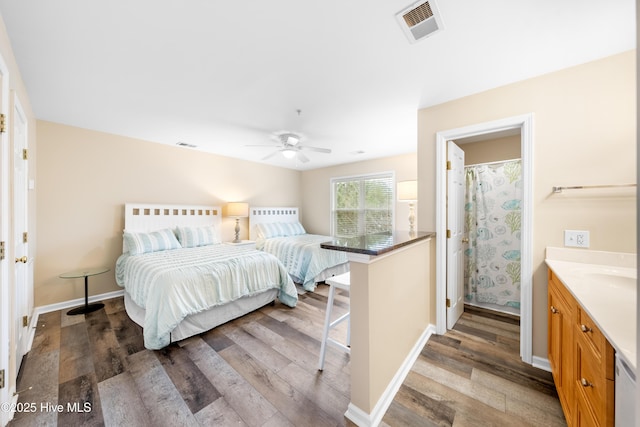 bedroom with ceiling fan, wood-type flooring, and connected bathroom