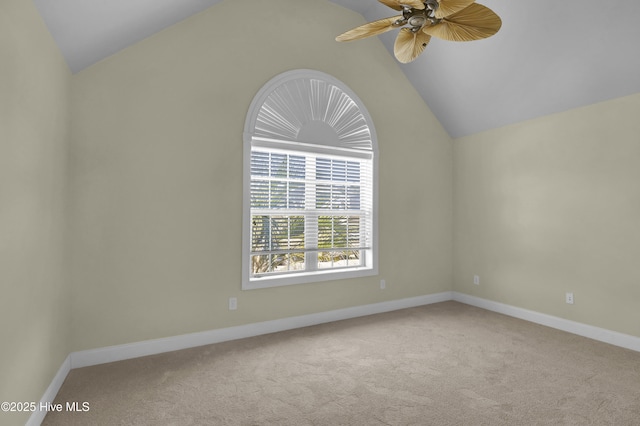 carpeted spare room featuring vaulted ceiling and ceiling fan