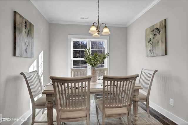 dining area with crown molding, a chandelier, and hardwood / wood-style flooring