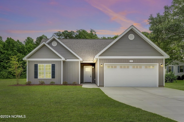 view of front of house with a yard and a garage