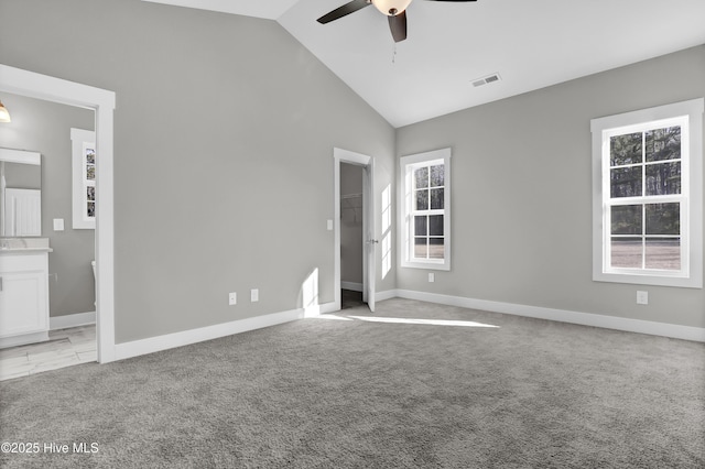 unfurnished bedroom with ensuite bathroom, high vaulted ceiling, ceiling fan, and light carpet