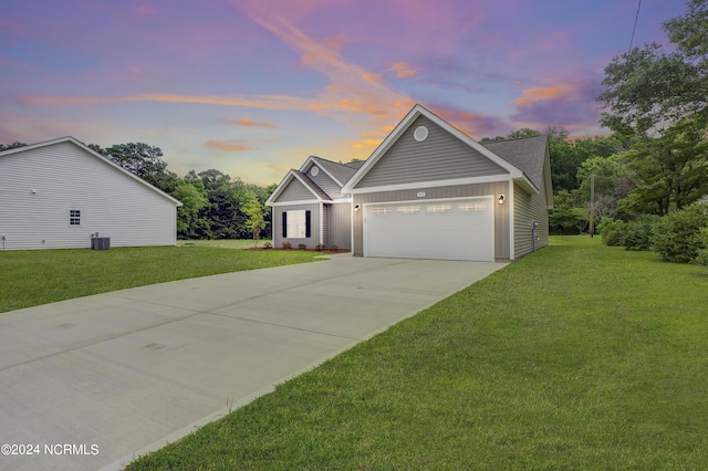 view of front of property with cooling unit, a garage, and a lawn