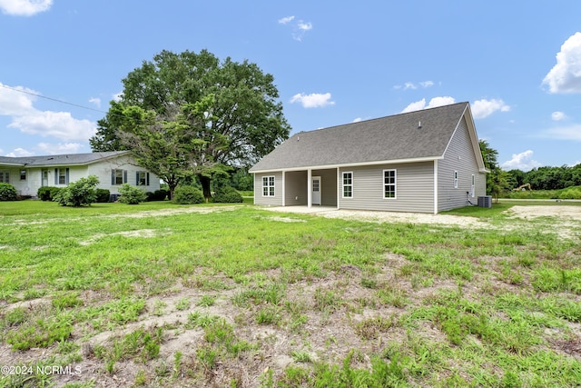 rear view of property with a patio, central air condition unit, and a yard