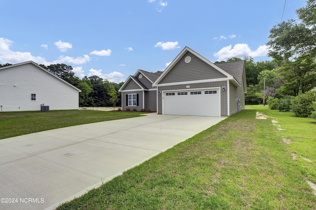 view of front of home with a front yard, a garage, and central air condition unit