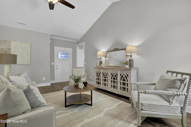 living room with ceiling fan, hardwood / wood-style floors, and vaulted ceiling