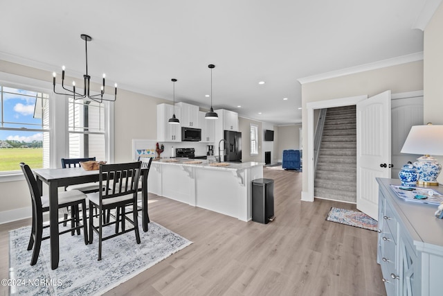 dining area featuring light hardwood / wood-style flooring, a chandelier, and ornamental molding