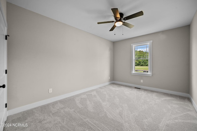 spare room featuring light carpet and ceiling fan