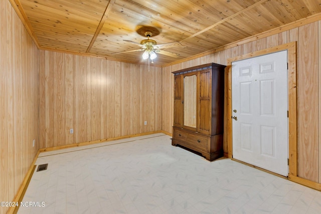 interior space featuring wooden ceiling, wood walls, and ceiling fan