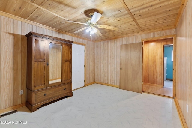 interior space with ceiling fan, wood walls, and wood ceiling