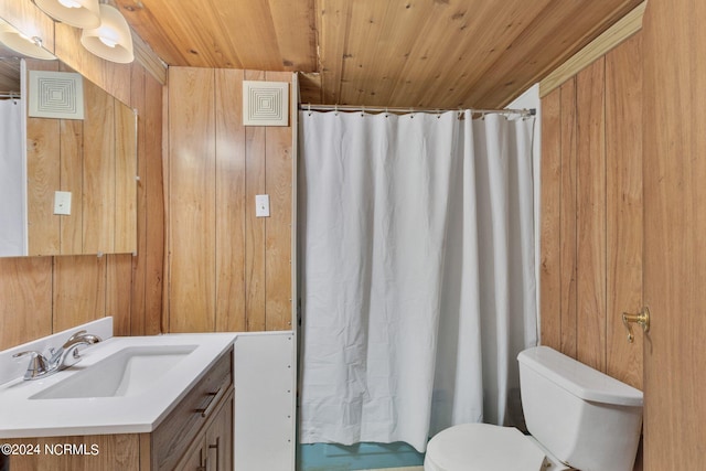 bathroom with vanity with extensive cabinet space, wooden walls, and toilet