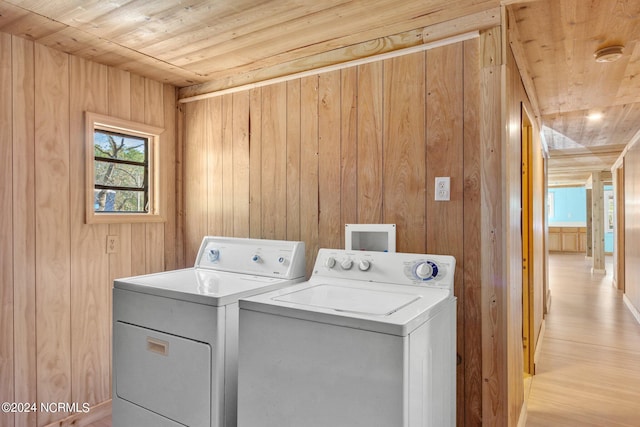 clothes washing area with light hardwood / wood-style floors, independent washer and dryer, washer hookup, wooden walls, and wood ceiling