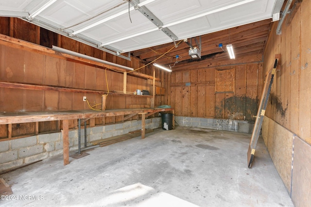 garage with a garage door opener and a workshop area