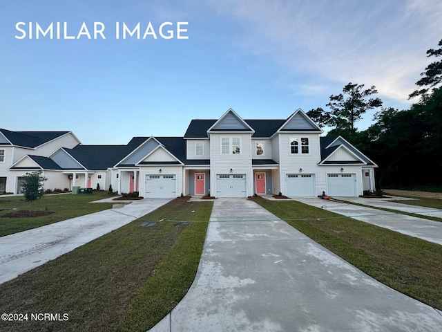 view of property with a garage and a front lawn