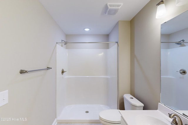 bathroom featuring a shower, vanity, and toilet