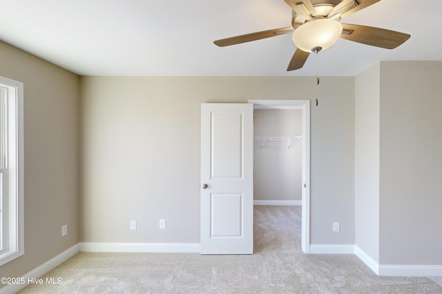 unfurnished bedroom featuring ceiling fan, light colored carpet, and a closet