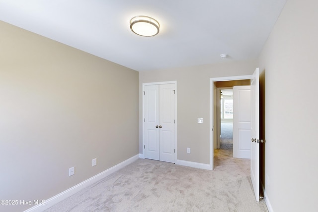 unfurnished bedroom with light carpet and a closet