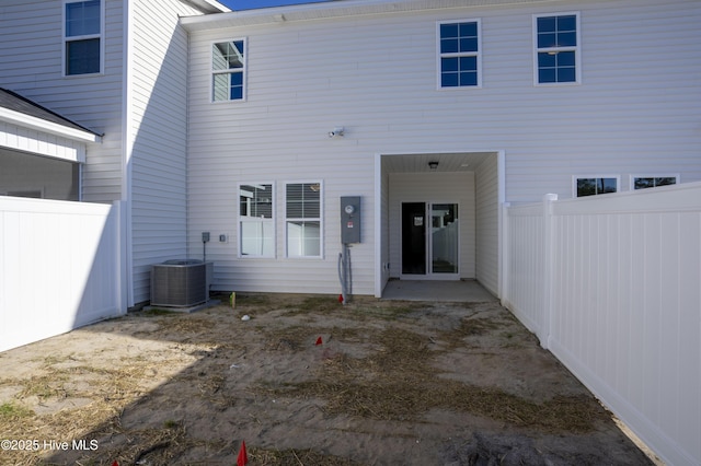 back of house with central AC unit