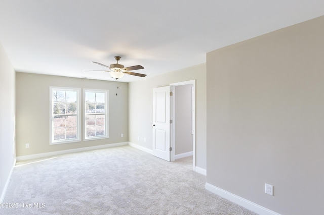 empty room with ceiling fan and light carpet