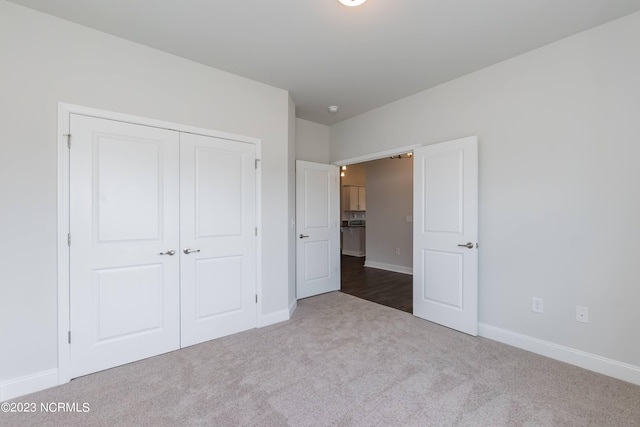 unfurnished bedroom featuring dark carpet and a closet