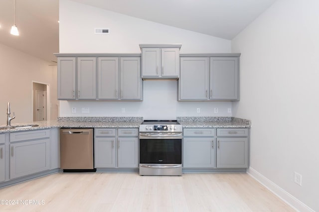 kitchen with appliances with stainless steel finishes, gray cabinetry, hanging light fixtures, light stone countertops, and sink