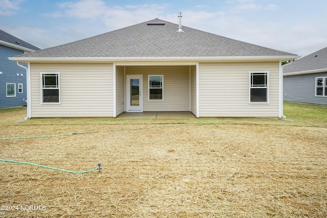 rear view of property with a lawn and a patio