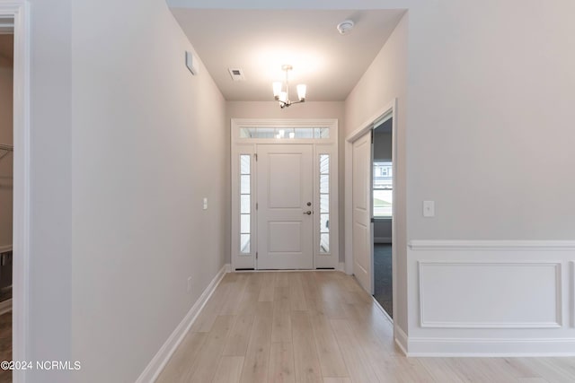 foyer with light hardwood / wood-style flooring and a notable chandelier