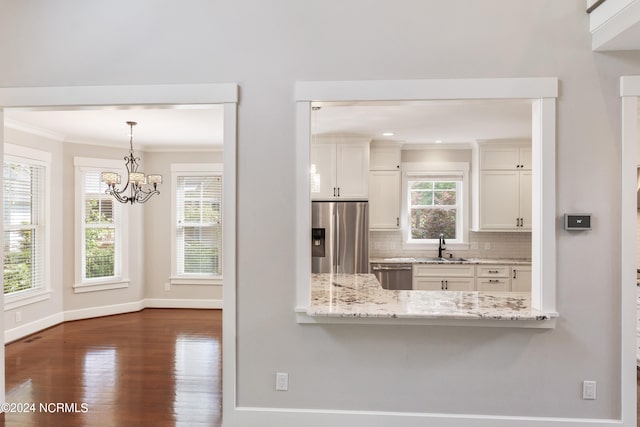 kitchen with dark hardwood / wood-style flooring, stainless steel appliances, light stone countertops, backsplash, and white cabinets