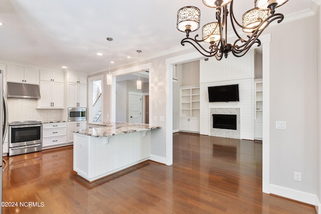 kitchen featuring light stone countertops, stainless steel appliances, dark wood-type flooring, pendant lighting, and white cabinetry