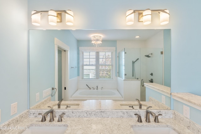 bathroom with separate shower and tub, vanity, and a chandelier