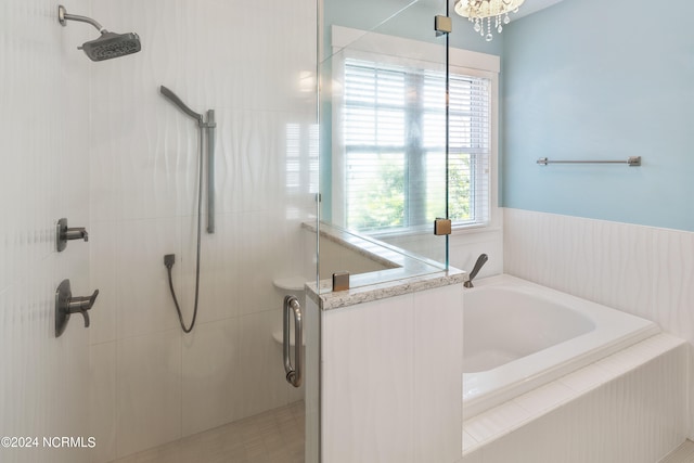 bathroom featuring shower with separate bathtub and a notable chandelier