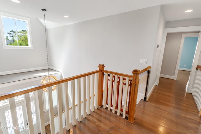 stairs with a notable chandelier and hardwood / wood-style flooring