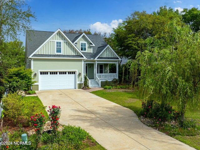 view of front of property with a porch, a front yard, and a garage