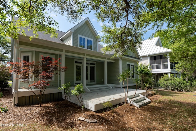 back of property with a sunroom and a wooden deck