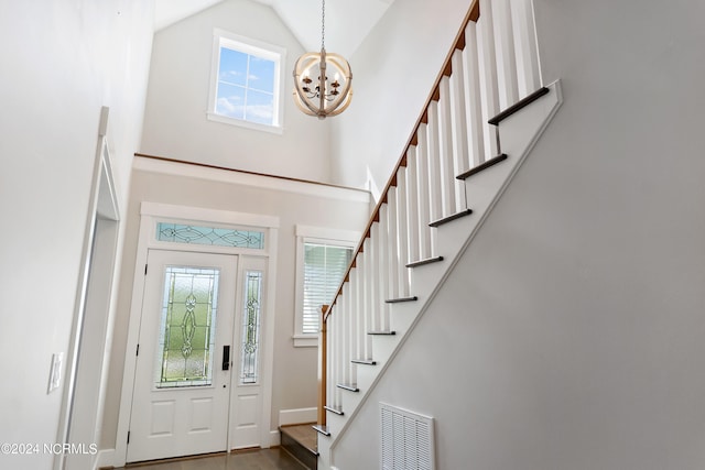 entryway with an inviting chandelier, hardwood / wood-style flooring, and high vaulted ceiling