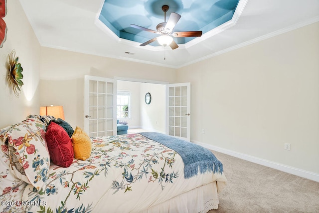 bedroom with ceiling fan, carpet, french doors, and a tray ceiling