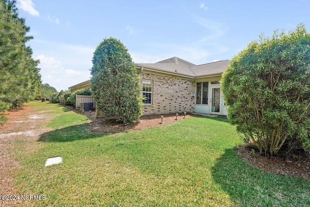 view of home's exterior with a yard and central AC unit